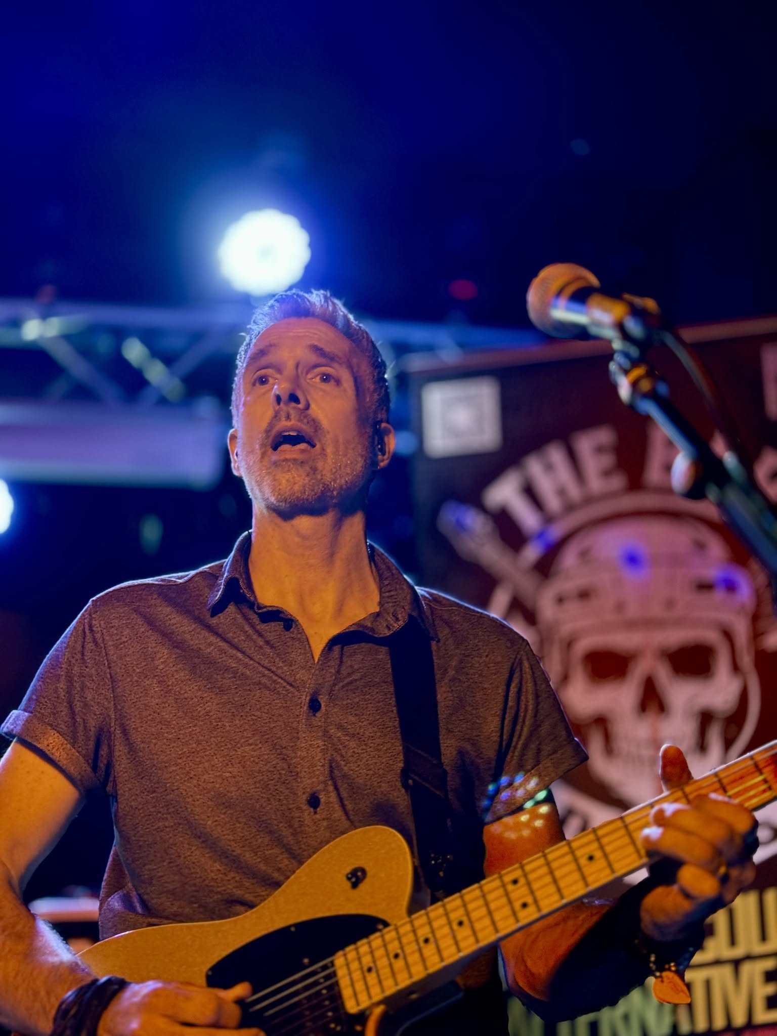 Scott playing guitar under blue and amber stage lights
